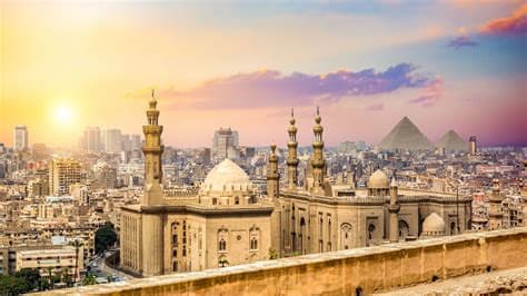 Cairo mosque and pyramids at sunset